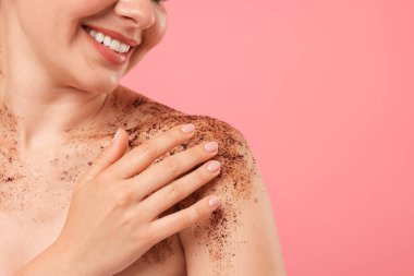 Gülümseyen kadın omuzlarını pembe arka plana yaslıyor, yakın plan. Metin için boşluk