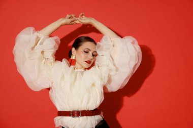 Kırmızı arka planda şık giyinmiş genç bir kadın.