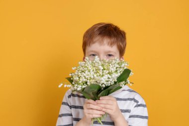 Sarı arka planda bir buket güzel çiçekli çocuk.