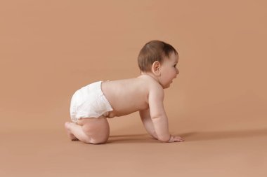 Bej arka planda emekleyen şirin bir bebek.