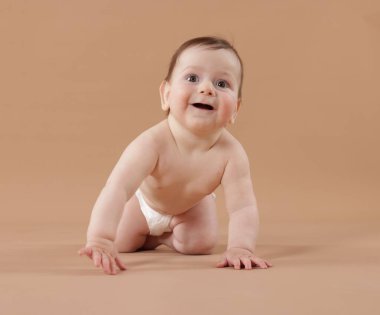 Bej arka planda emekleyen şirin bir bebek.