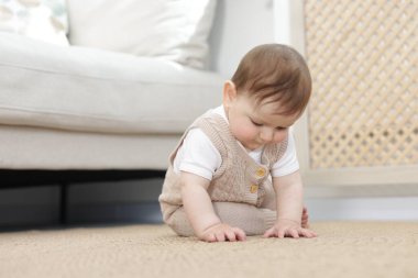 Evde yerde oturan şirin bir bebek.