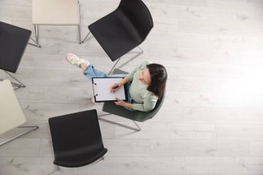 Profesyonel psikolog, grup terapisi için hazırlanmış sandalyelerle odada.