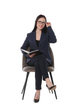 Ofis koltuğunda beyaz arka planda not defteri olan profesyonel psikolog.