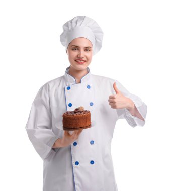 Üniformalı mutlu pastacı lezzetli çikolatalı pasta tutuyor ve beyaz arka planda baş parmak gösteriyor.