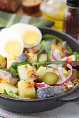 Ringa balıklı lezzetli salata, yumurta ve sebzeler masada, yakın plan.