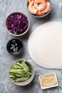 Pirinç kağıt çarşaflar ve açık gri masa üzerindeki farklı malzemeler, düz uzanmış.