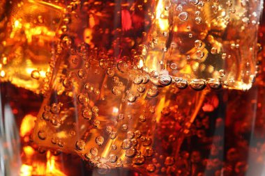 Arkaplan olarak buz küpleriyle kola tazeleniyor, makro görünüm