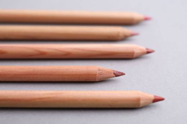 Açık gri arkaplanda pek çok farklı dudak kalemi, yakın plan