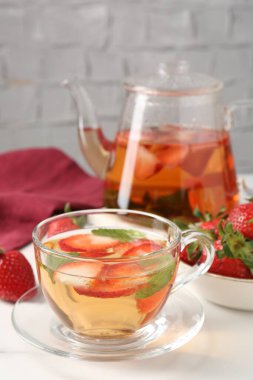 Aromatik çilekli meyve çayı ve beyaz masada nane şekeri, yakın plan.