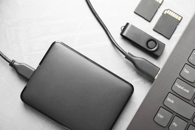Gri desenli tablo üzerinde dizüstü bilgisayara, SD hafıza kartlarına ve flash diske bağlı harici sabit disk, düz konum