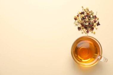 Cam fincanda nefis bitki çayı ve bej arka planda kuru yapraklar, düz yatak. Metin için boşluk
