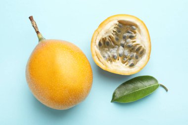 Olgun sarı çarkıfelek meyveleri ve açık mavi arka planda yaprak, düz yatıyordu.