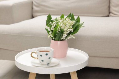 Bir buket güzel vadi zambağı ve bir fincan çay.