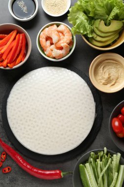 Pilav kağıtları ve farklı malzemeler koyu gri masada, düz yerde.