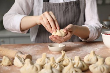 Mutfaktaki masada khinkali yapan kadın, yakın plan.