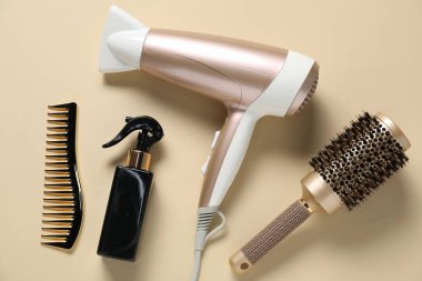 Bej arka planda yuvarlak fırça, sprey, tarak ve kurutucu, düz uzanma