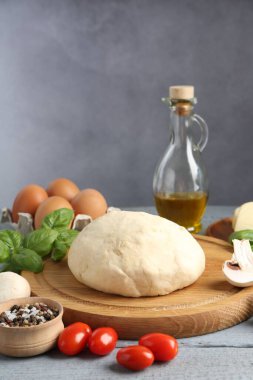 Pizza yapıyorum. Gri ahşap masadaki farklı malzemeler.