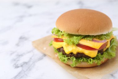 Beyaz mermer masada leziz bir çizburger, yakın plan. Metin için boşluk