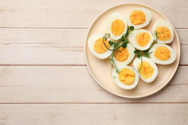 Haşlanmış yumurta ve mikroyeşillikler ahşap masada, üst manzara. Metin için boşluk
