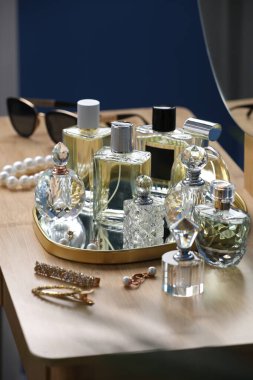 İçerideki ahşap masada parfüm şişeleri.