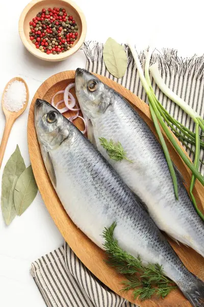 Tuzlu ringa balıkları ve baharatlar beyaz ahşap masada, düz yatıyordu.