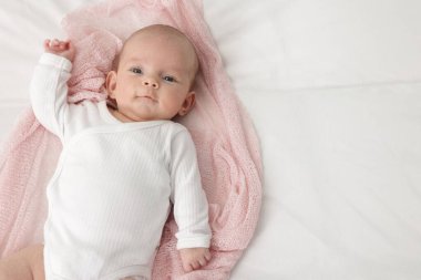 Evdeki yatakta uzanmış şirin küçük bebek, üst manzara. Metin için boşluk