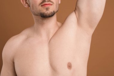 Kahverengi arka planda epilasyon işleminden sonra koltukaltı pürüzsüz görünüyor.