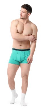 Beyaz arka planda şık turkuaz iç çamaşırlı genç adam.