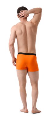 Beyaz arka planda şık turuncu iç çamaşırlı genç adam.