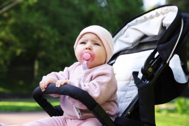 Parktaki bebek arabasında şirin bir bebek.