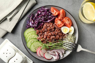 Gri masada servis edilen kahverengi pirinçli lezzetli salata.