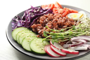 Beyaz ahşap masada kahverengi pirinçli lezzetli salata, yakın plan.