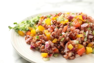 Beyaz mermer masada kahverengi pirinçli lezzetli salata, yakın plan.