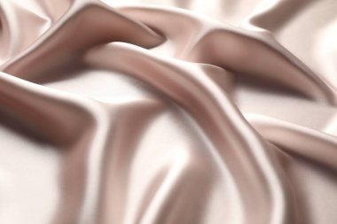 Arkaplan olarak bej buruşuk ipek kumaş, yakın plan