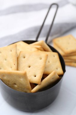 Beyaz fayanslı masada lezzetli tuzlu krakerler, yakın plan.