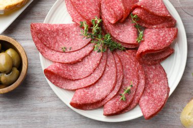 Dilimler dolusu lezzetli sosis ve kekik hafif ahşap masada servis edilir.