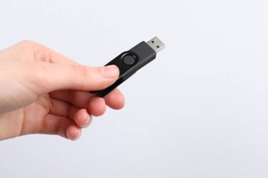 Açık gri arka planda modern flash diski olan adam, yakın plan. Metin için boşluk