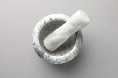 Açık gri zemin üzerinde mermer harç ve tokmak, üst görünüm