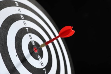 Hedef alınıyor. Siyah arkaplanda ok olan dart tahtası, yakın plan