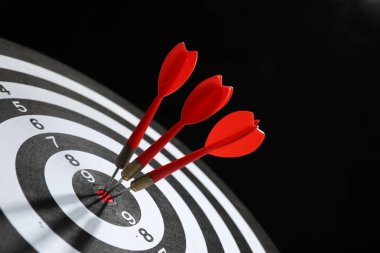 Hedef alınıyor. Siyah arkaplanda okları olan dart tahtası, yakın plan