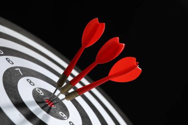 Hedef alınıyor. Siyah arkaplanda okları olan dart tahtası, yakın plan