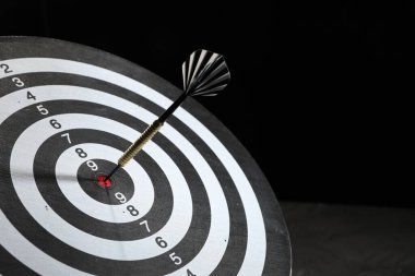 Hedef alınıyor. Karanlık arkaplanda ok olan dart tahtası, yakın plan