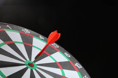 Hedef alınıyor. Karanlık arkaplanda ok olan dart tahtası, yakın plan