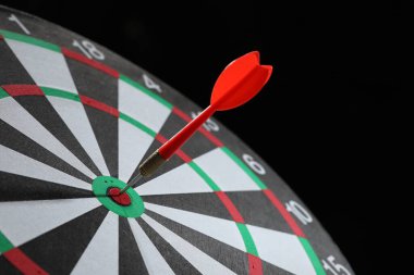 Hedef alınıyor. Siyah arkaplanda ok olan dart tahtası, yakın plan
