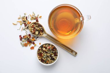 Beyaz arka planda lezzetli bitki çayı ve kuru yapraklar, üst manzara.