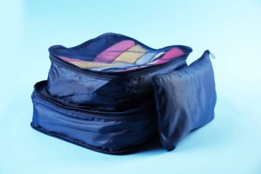 Açık mavi arkaplanda giysileri olan küpler paketleniyor, yakın plan