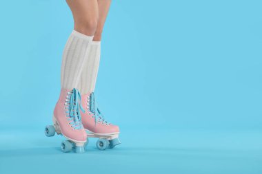Açık mavi arka planda patenli bir kadın, yakın plan. Metin için boşluk