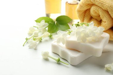 Sabun kalıpları, yasemin çiçekleri ve beyaz mermer masada havlu, yakın plan.