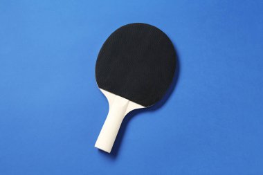 Mavi arka planda bir ping pong raketi, üst görünümde.